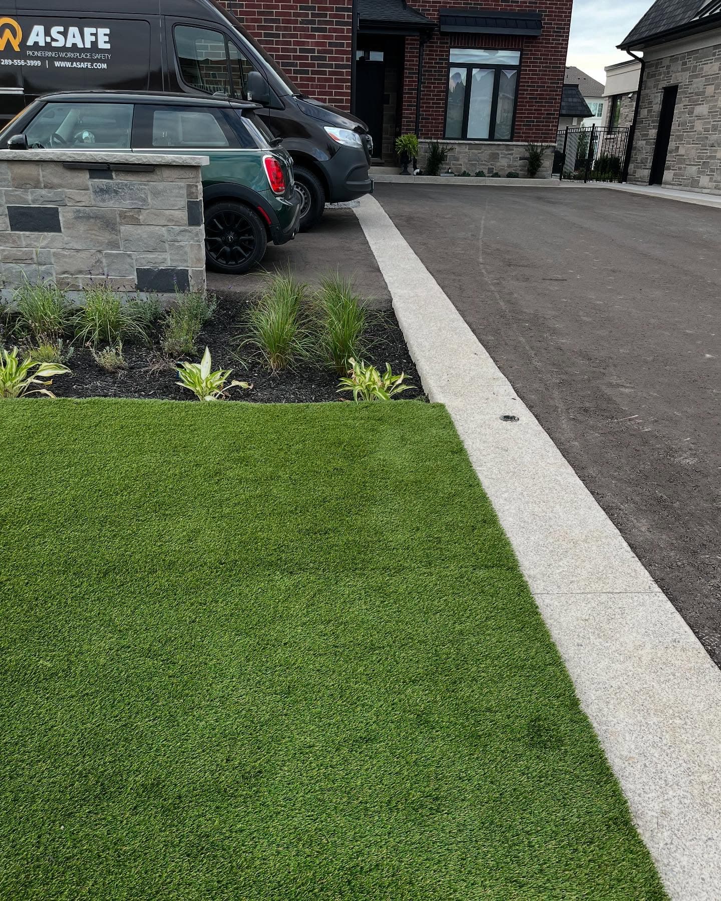 New sod and curbing along a finished driveway